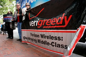 Members of CWA and Jobs for Justice hold a banner in front of the Verizon store on Market street in San Francisco on Friday June 22 as part of a rally put on to encourage customers to boycott the company due to executive pay raises and workers pay cuts. Photo by Andy Sweet