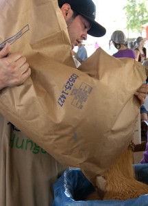 Kyle Brabender, 27, pours a 50 pound bag of soy into a container for volunteers to put into bags during the Kids Against Hunger event at the Alameda County Fairgrounds in Pleasanton, Calif. last Wednesday (June 27, 2012). Volunteers and the public came together to package 100 thousand bags of food in 10 hours to ship to Haiti by the end of next week to help feed the under resourced.
By: Jessica Worthington