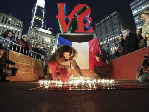 A mourner lights candles in LOVE Park in Philadelphia on Nov. 14, 2015, during a vigil to remember the victims of the attacks in Paris. Photo by Joseph Kaczmarek.