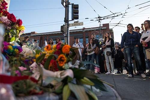 People gather around a memorial at Castro and 18th streets on Sunday to remember the lives lost in a nightclub shooting in Orlando, Fla. (Jessica Christian/S.F. Examiner)