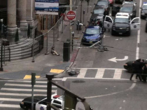 A man lay prostrate on the corner of Jones and McAllister streets, 7/9/16, during a tense 3 hour standoff with SFPD. Photo via SF Examiner.